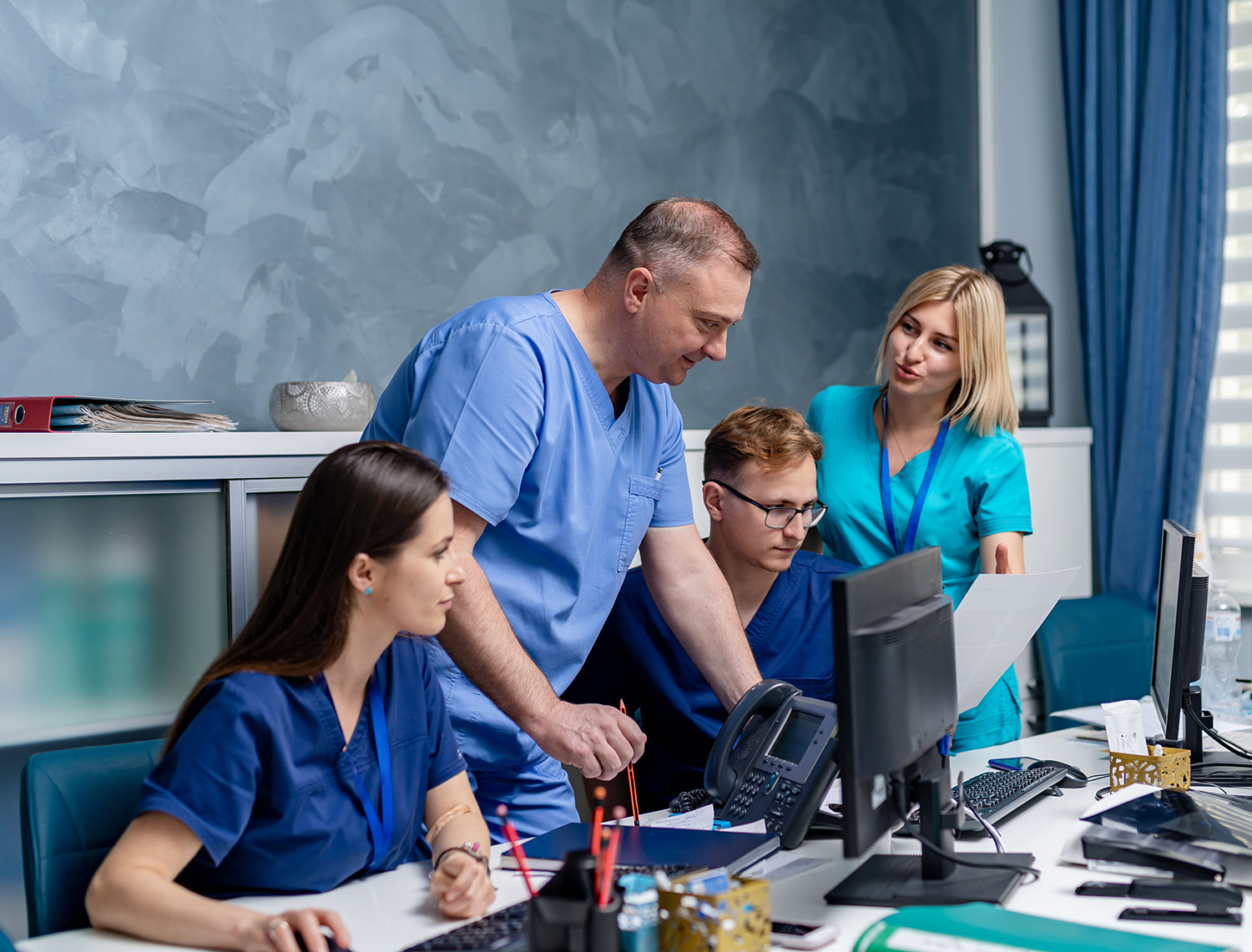 Medical team discussing diagnosis in office. Men and women medics.